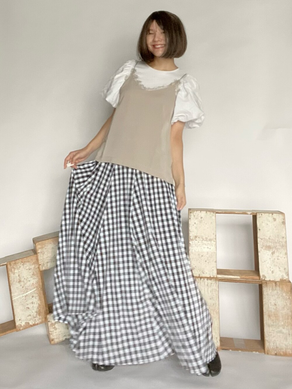 ベージュ系のキャミソール、ブラック系のスカート、ブラック系のシューズを着用したレディースの春コーディネートの2枚目の写真