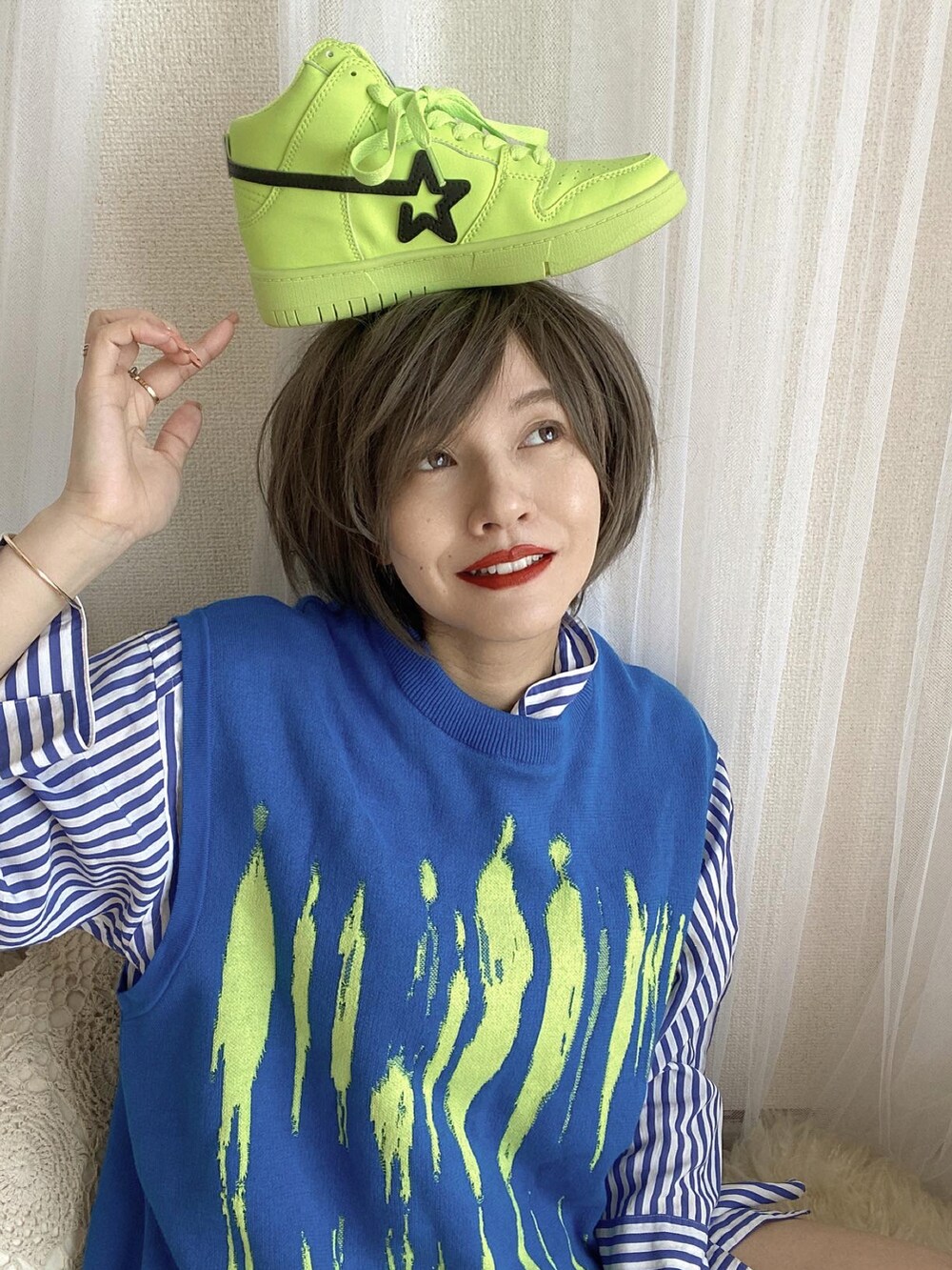 グリーン系のスニーカー、ブルー系のシャツワンピース、ブルー系のベストを着用したレディースの冬コーディネートの2枚目の写真