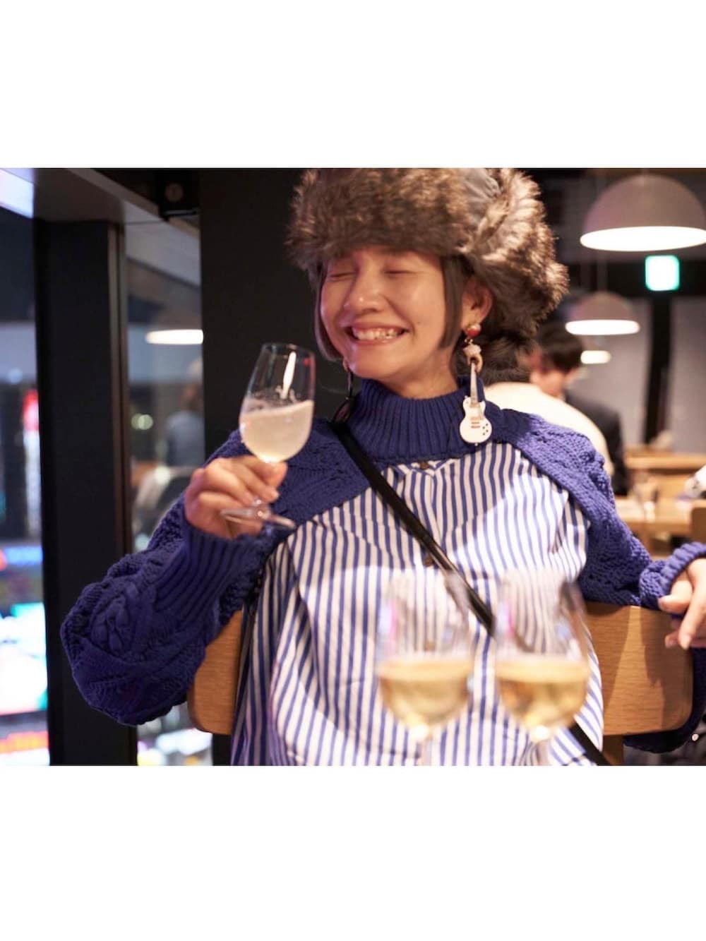 ブラック系のバッグ、ブルー系のシャツワンピース、グレー系のキャップを着用したレディースの冬コーディネートの2枚目の写真