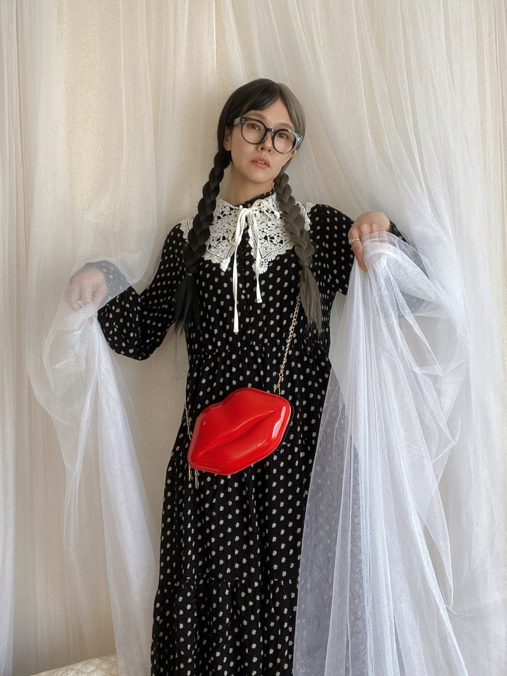 ブラック系のワンピース、レッド系のバッグを着用したレディースの冬コーディネートの2枚目の写真