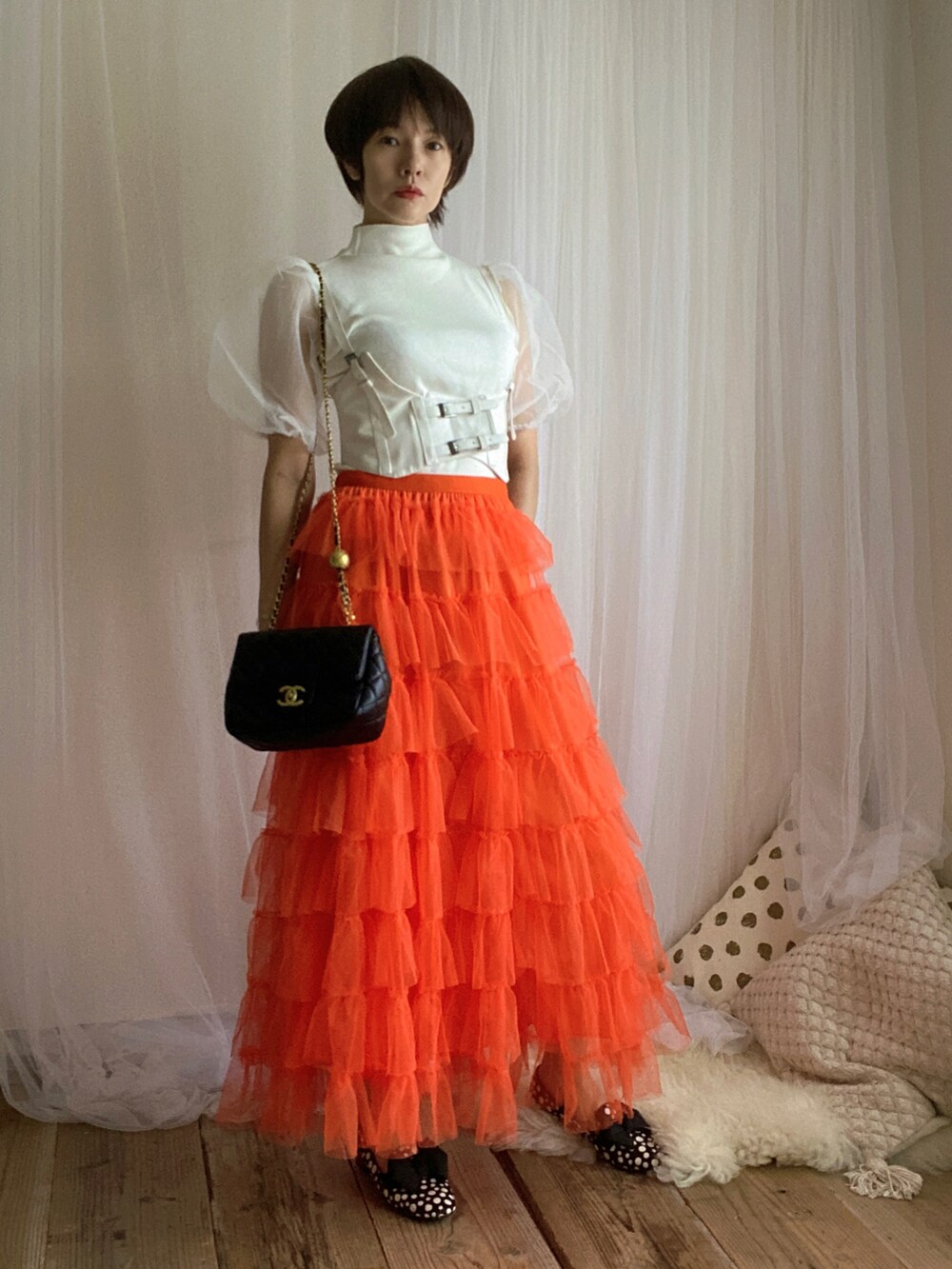 ホワイト系のTシャツ/カットソー、オレンジ系のスカート、ブラック系のバッグを着用したレディースの夏コーディネートの3枚目の写真