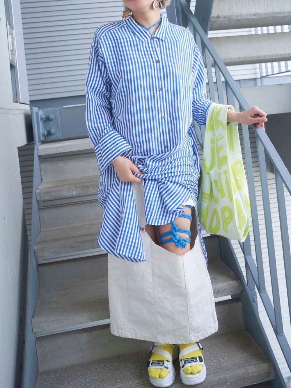ブルー系のシャツワンピース、ホワイト系のシューズ、その他のソックス/靴下を着用したレディースの春コーディネートの2枚目の写真