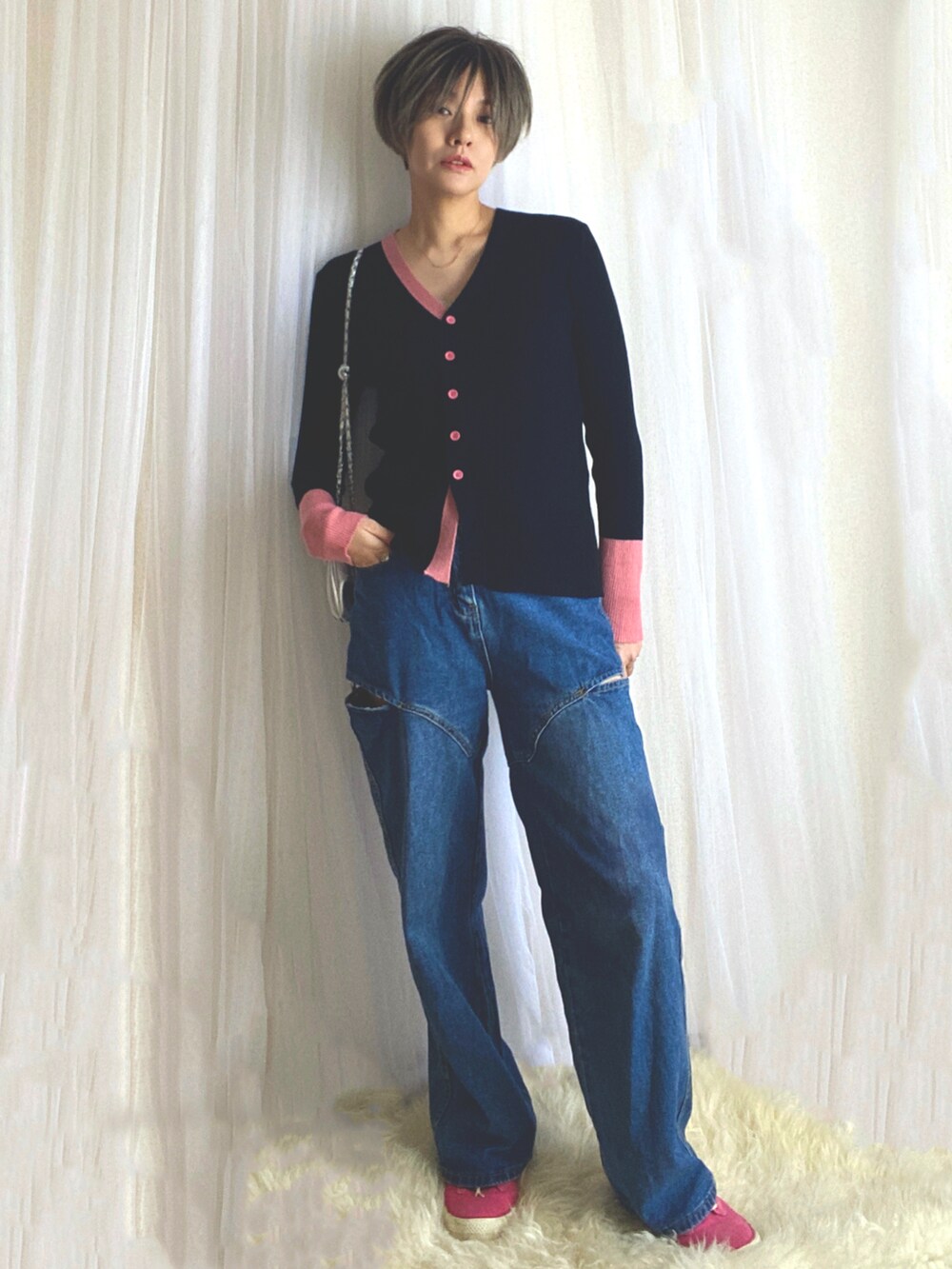 ブラック系のカーディガン/ボレロ、ブルー系のデニムパンツ、ピンク系のスニーカーを着用したレディースの冬コーディネートの3枚目の写真