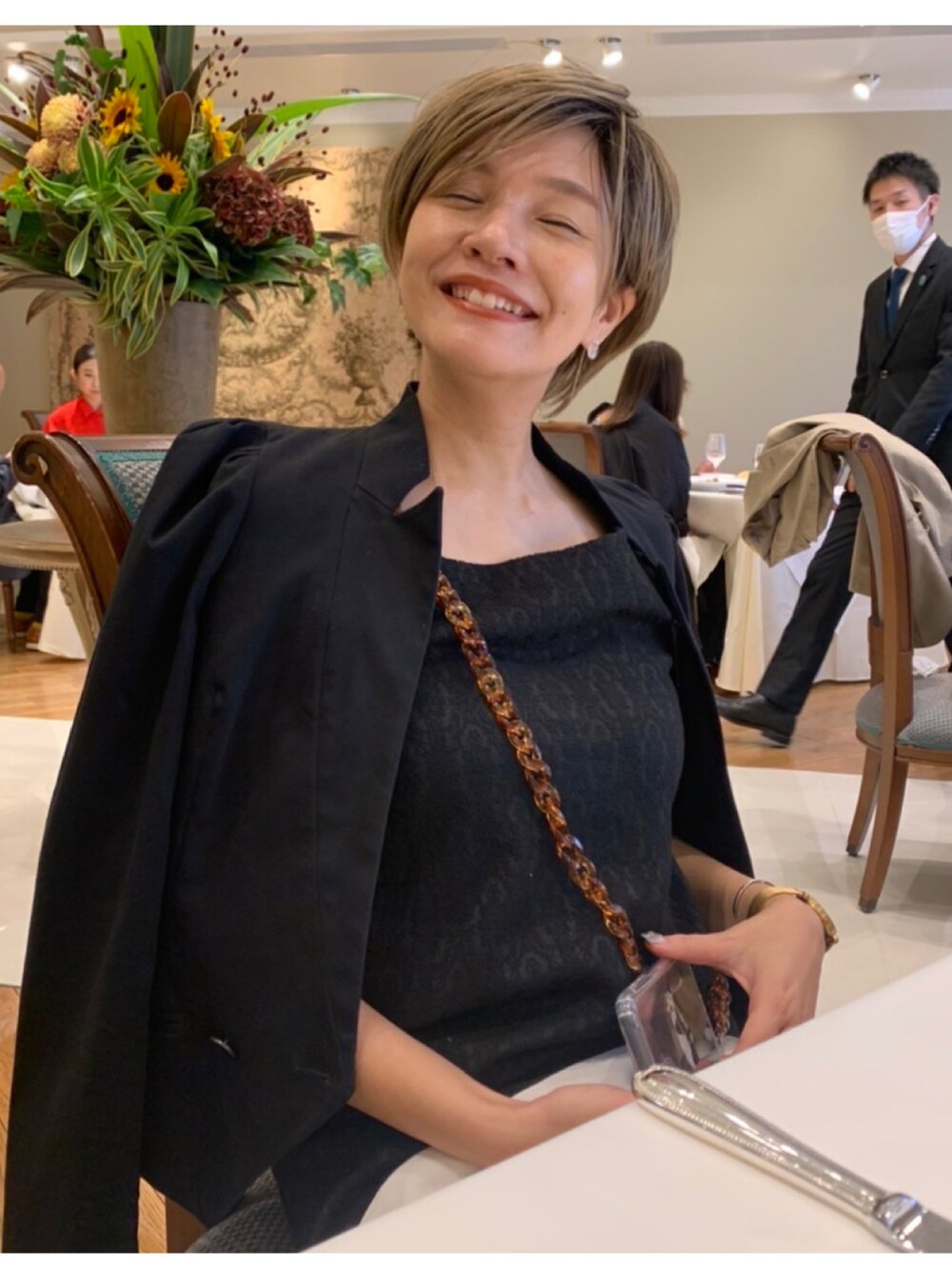 ブラック系のワンピース/ドレス、ブラック系のテーラードジャケット、ブラック系のブーツを着用したレディースの秋コーディネートの2枚目の写真