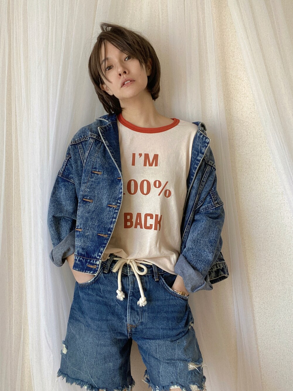 ブルー系のデニムパンツ、ブルー系のデニムジャケット、オレンジ系のTシャツ/カットソーを着用したレディースの冬コーディネートの2枚目の写真