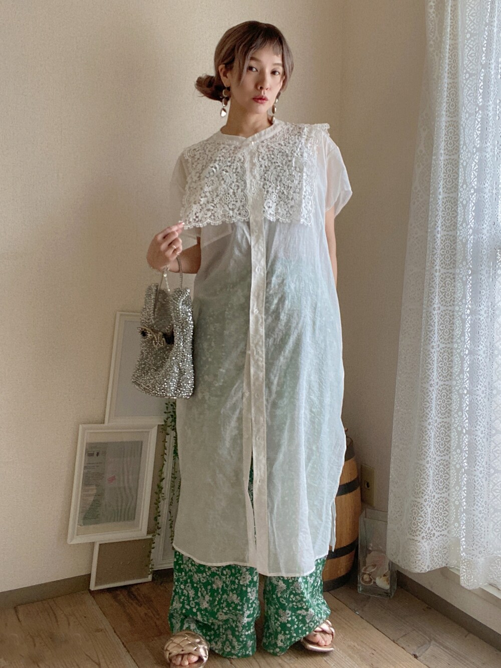 シルバー系のバッグ、ホワイト系のワンピース、グリーン系のその他パンツを着用したレディースの夏コーディネートの2枚目の写真