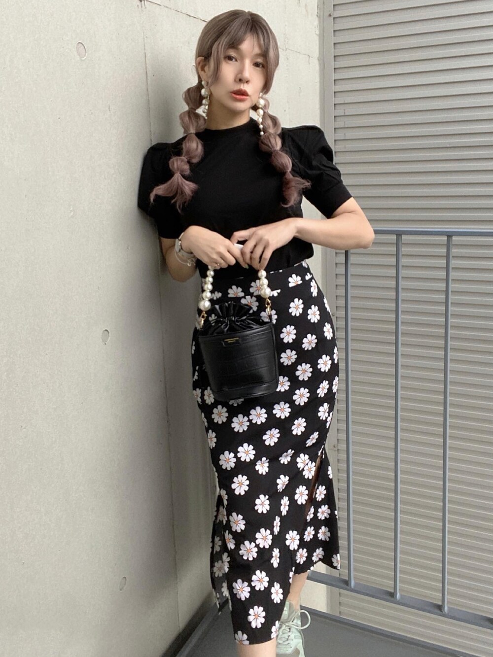 ブラック系のセットアップ、グリーン系のスニーカー、ホワイト系のハンチング/ベレー帽を着用したレディースの春コーディネートの2枚目の写真