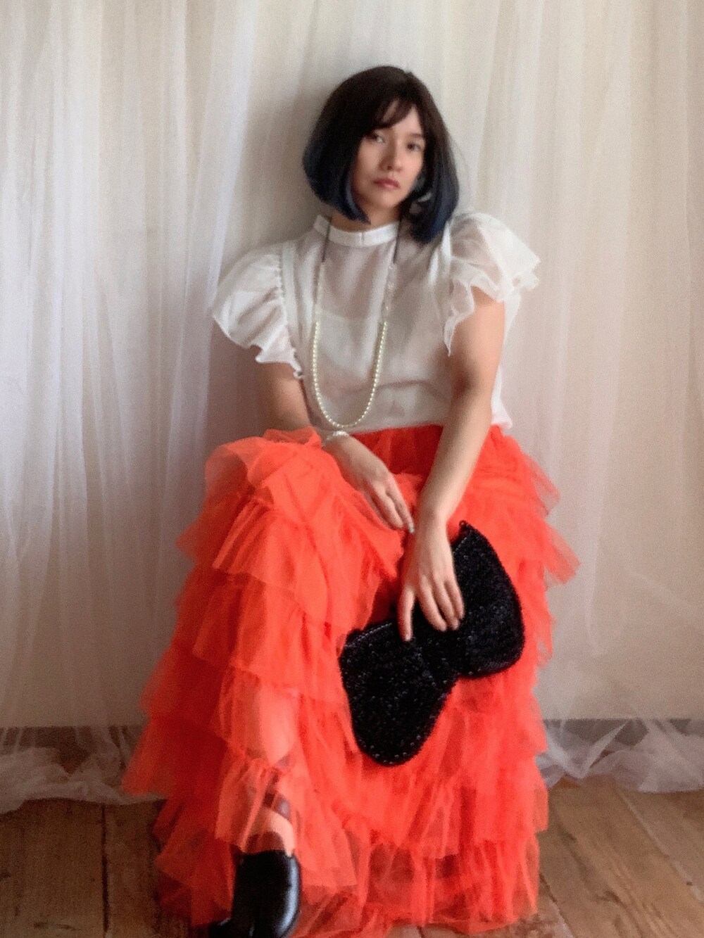 ホワイト系のシャツ/ブラウス、オレンジ系のスカート、ブラック系のシューズを着用したレディースの夏コーディネートの2枚目の写真