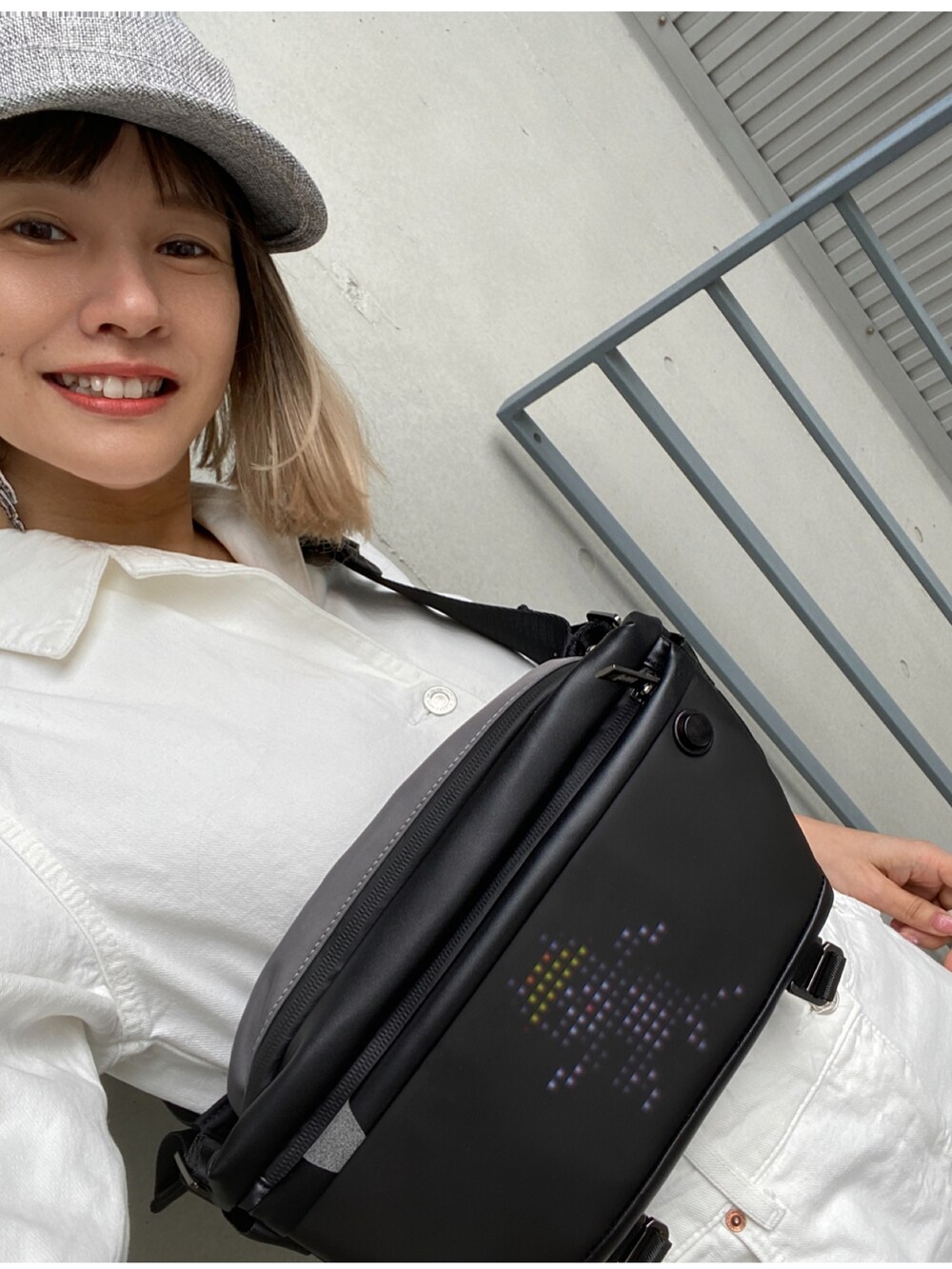 ホワイト系のスニーカー、ホワイト系のオールインワン・サロペット、グレー系のキャップを着用したレディースの春コーディネートの3枚目の写真