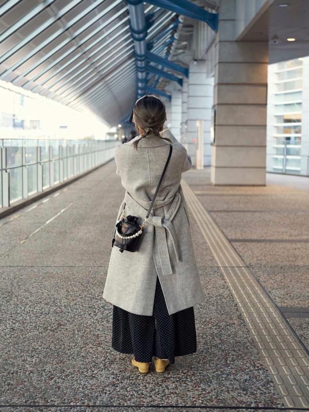 ホワイト系のジャケット/アウター、ブラック系のその他パンツ、イエロー系のシューズを着用したレディースの冬コーディネートの2枚目の写真