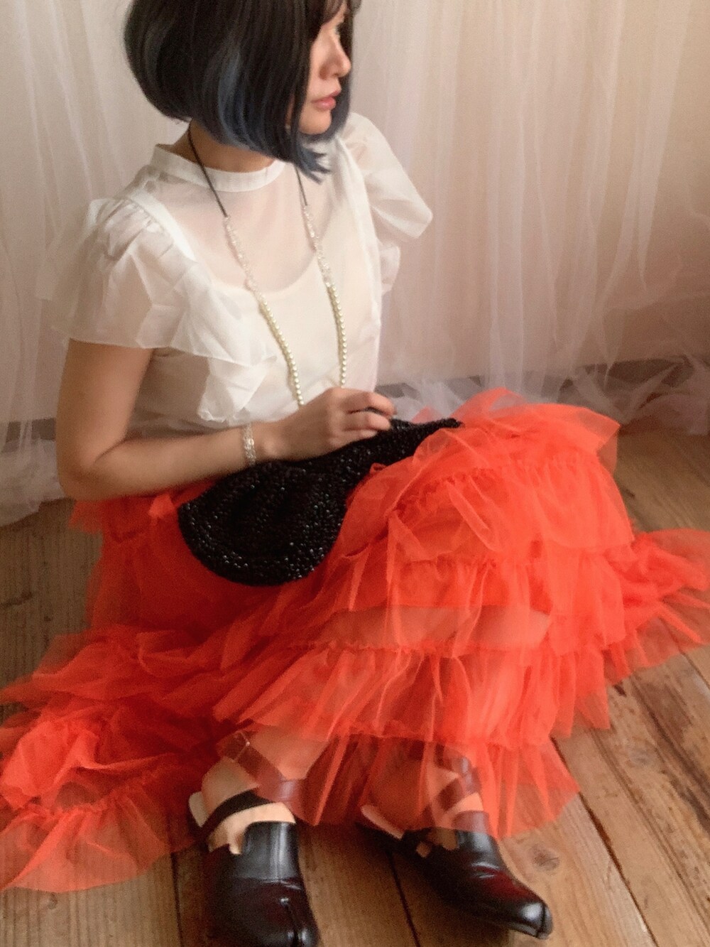 ホワイト系のシャツ/ブラウス、オレンジ系のスカート、ブラック系のシューズを着用したレディースの夏コーディネートの3枚目の写真