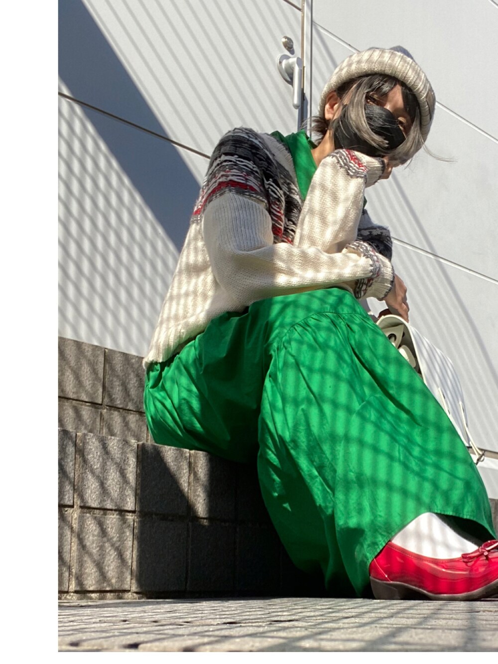 レッド系のパンプス、グリーン系のワンピース/ドレス、ホワイト系のバックパック/リュックを着用したレディースの秋コーディネートの3枚目の写真