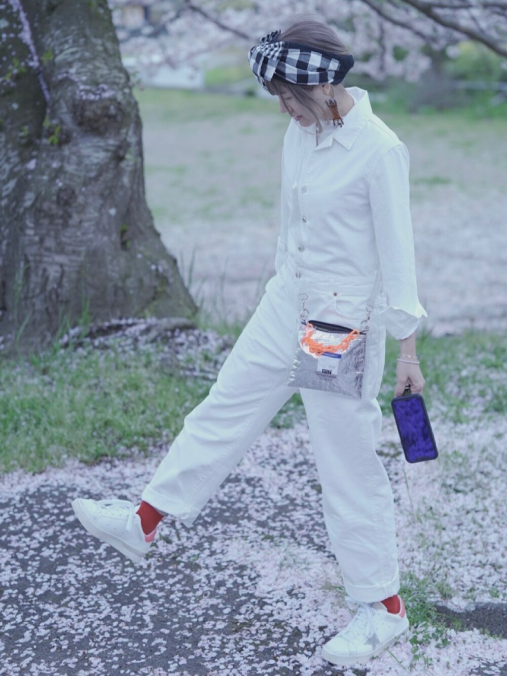 ホワイト系のスニーカー、ホワイト系のオールインワン・サロペット、ブラック系のその他ヘアアクセサリーを着用したレディースの春コーディネートの3枚目の写真
