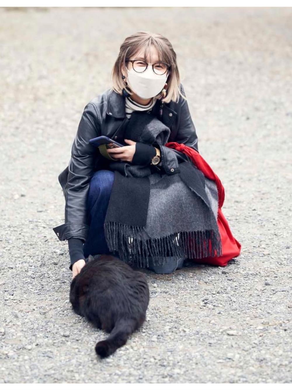 ブルー系のデニムパンツ、ホワイト系のニット/セーター、レッド系のショルダーバッグを着用したレディースの春コーディネートの4枚目の写真