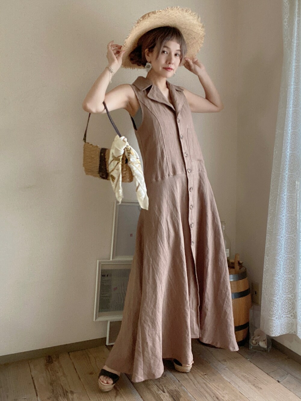 ベージュ系のバッグ、ブラック系のサンダル、ブラウン系のワンピース/ドレスを着用したレディースの夏コーディネートの2枚目の写真