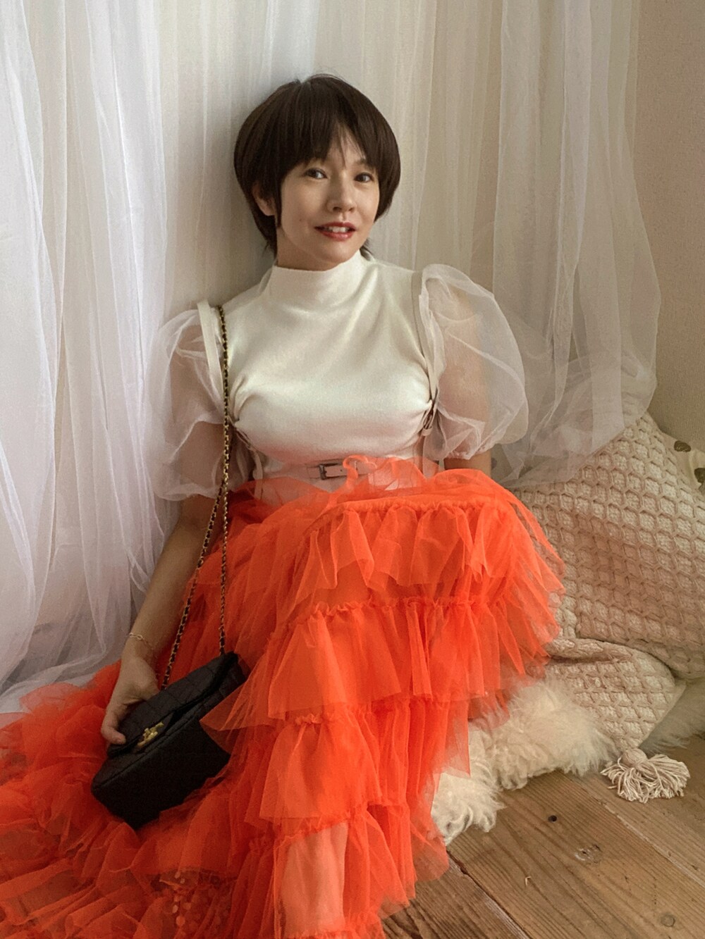 ホワイト系のTシャツ/カットソー、オレンジ系のスカート、ブラック系のバッグを着用したレディースの夏コーディネートの2枚目の写真