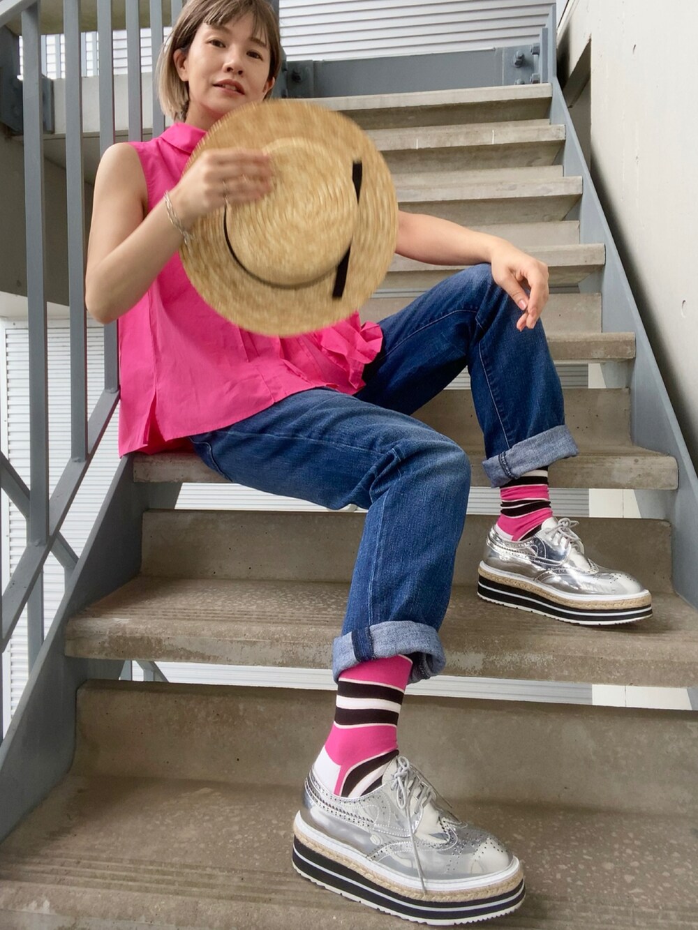 ブルー系のデニムパンツ、ピンク系のシャツ/ブラウス、シルバー系のシューズを着用したレディースの夏コーディネートの2枚目の写真