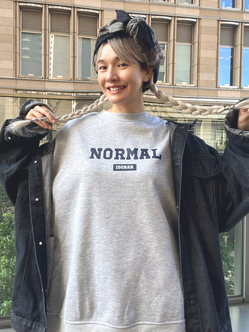 ブラック系のスカート、グレー系のスウェット、ブルー系のスニーカーを着用したレディースの秋コーディネートの3枚目の写真