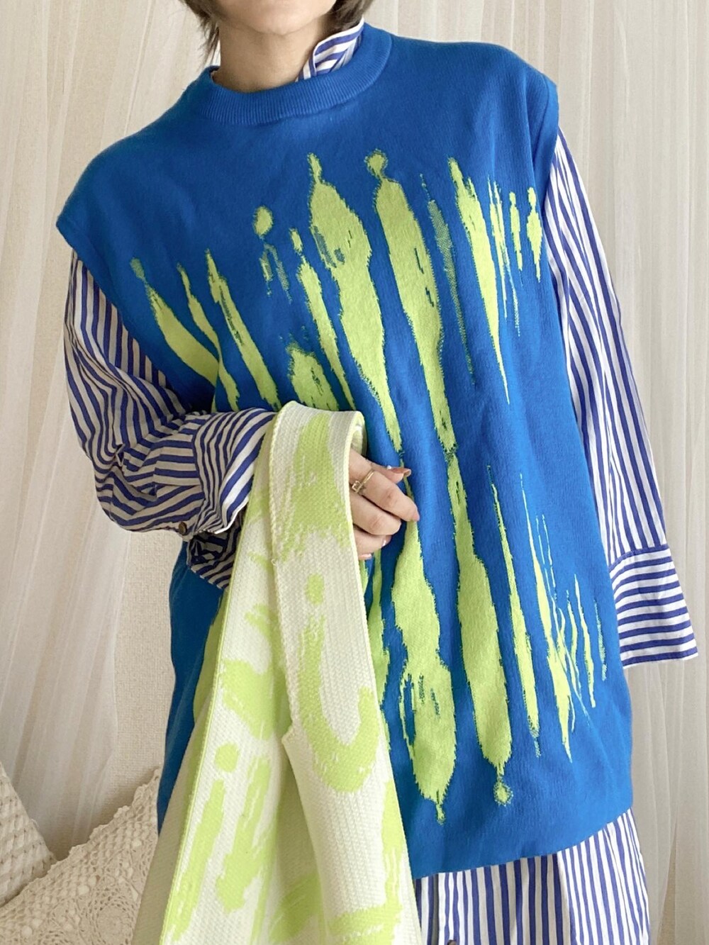 グリーン系のスニーカー、ブルー系のシャツワンピース、ブルー系のベストを着用したレディースの冬コーディネートの4枚目の写真