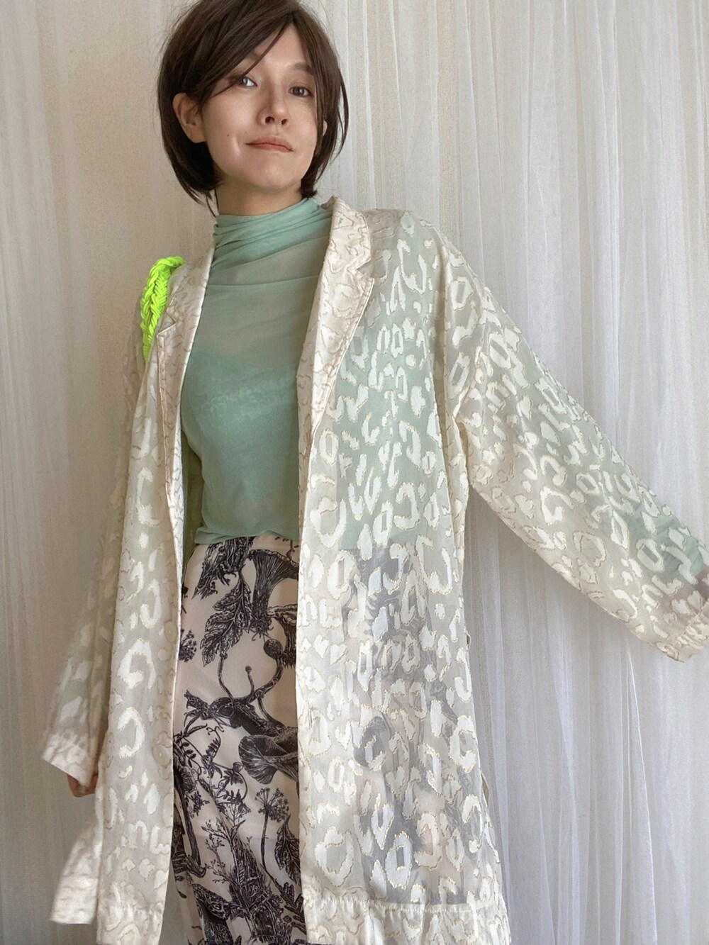 グリーン系のTシャツ/カットソー、ホワイト系のスカート、ホワイト系のテーラードジャケットを着用したレディースの冬コーディネートの3枚目の写真