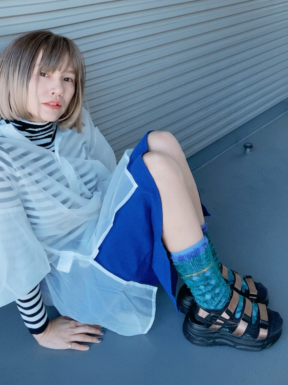 ブラウン系のサンダル、ホワイト系のシャツ/ブラウス、ブルー系のスカートを着用したレディースの春コーディネートの3枚目の写真