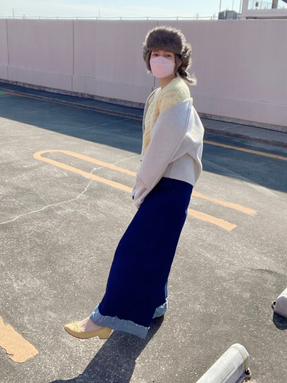 ブルー系のデニムパンツ、イエロー系のシューズ、グレー系のキャップを着用したレディースの冬コーディネートの3枚目の写真