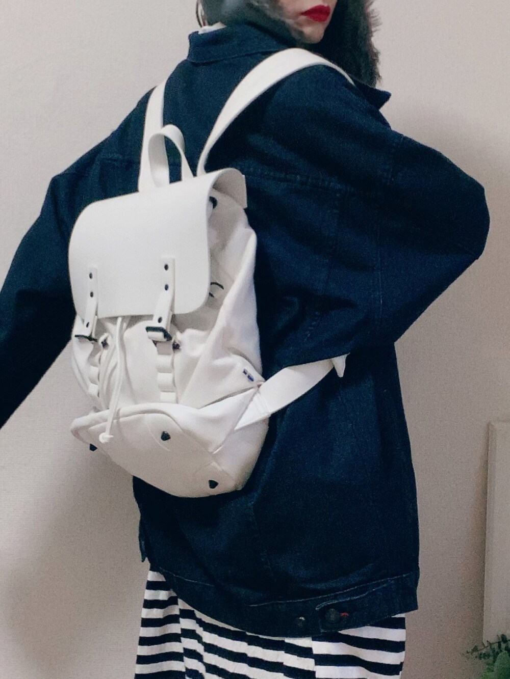 ホワイト系のワンピース、ブルー系のデニムジャケット、グレー系のキャップを着用したレディースの冬コーディネートの2枚目の写真