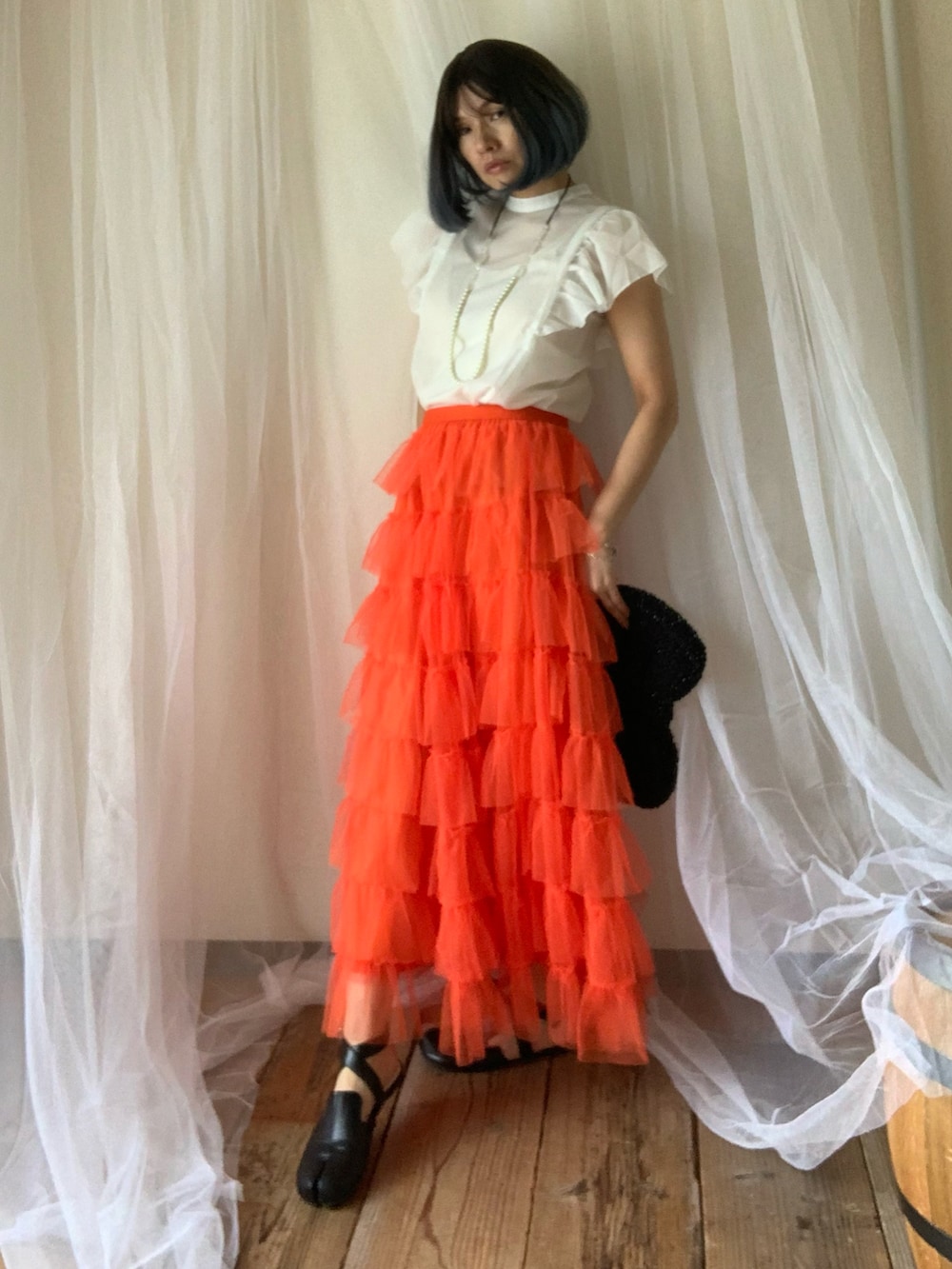 ホワイト系のシャツ/ブラウス、オレンジ系のスカート、ブラック系のシューズを着用したレディースの夏コーディネートの5枚目の写真