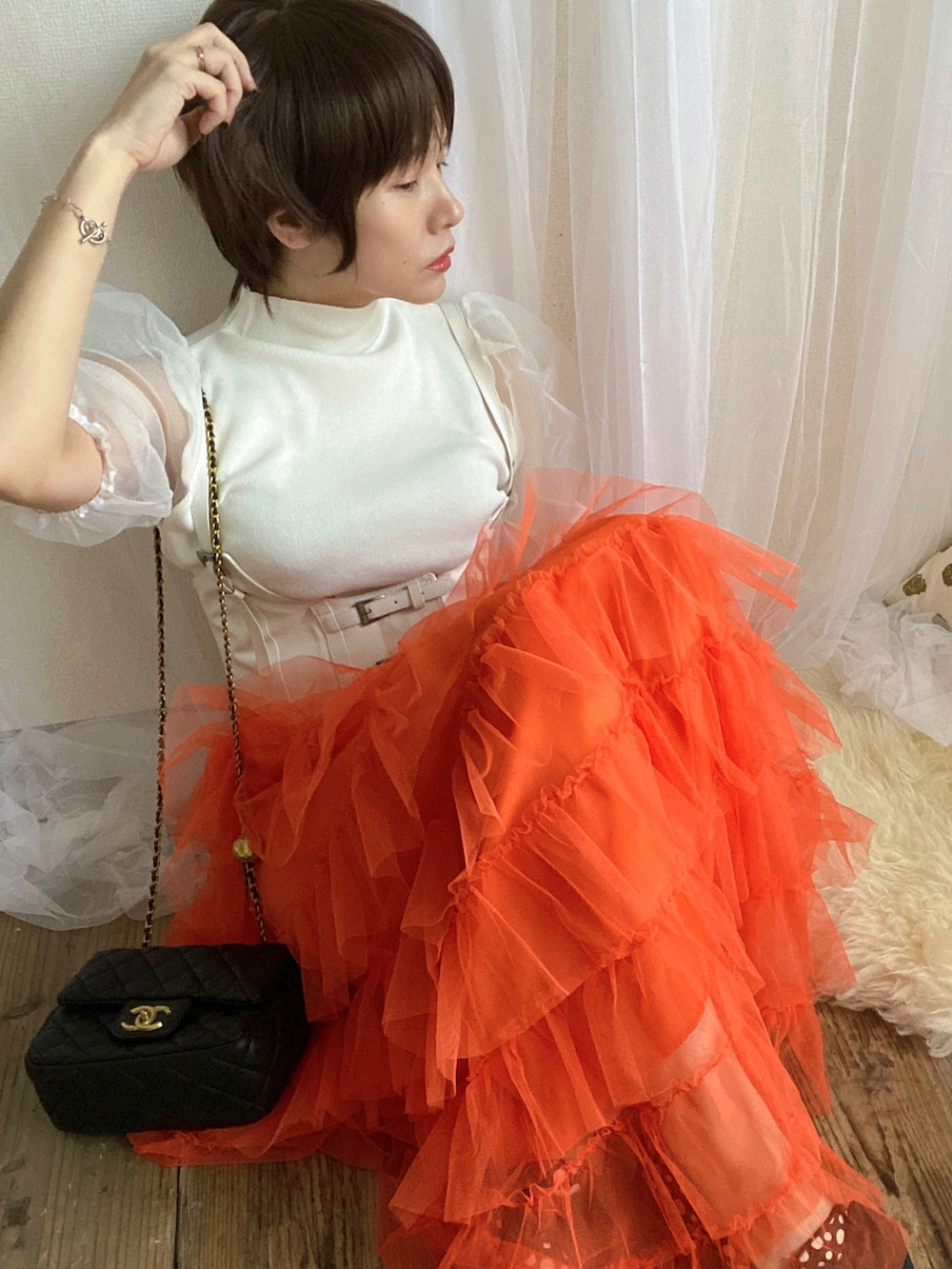 ホワイト系のTシャツ/カットソー、オレンジ系のスカート、ブラック系のバッグを着用したレディースの夏コーディネートの4枚目の写真
