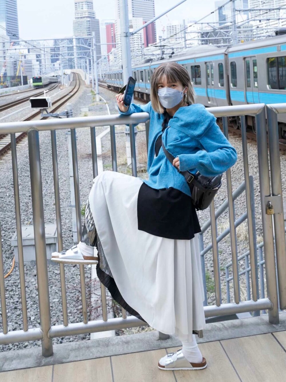 ブルー系のカーディガン/ボレロ、シルバー系のサンダル、シルバー系のスカートを着用したレディースの春コーディネートの3枚目の写真