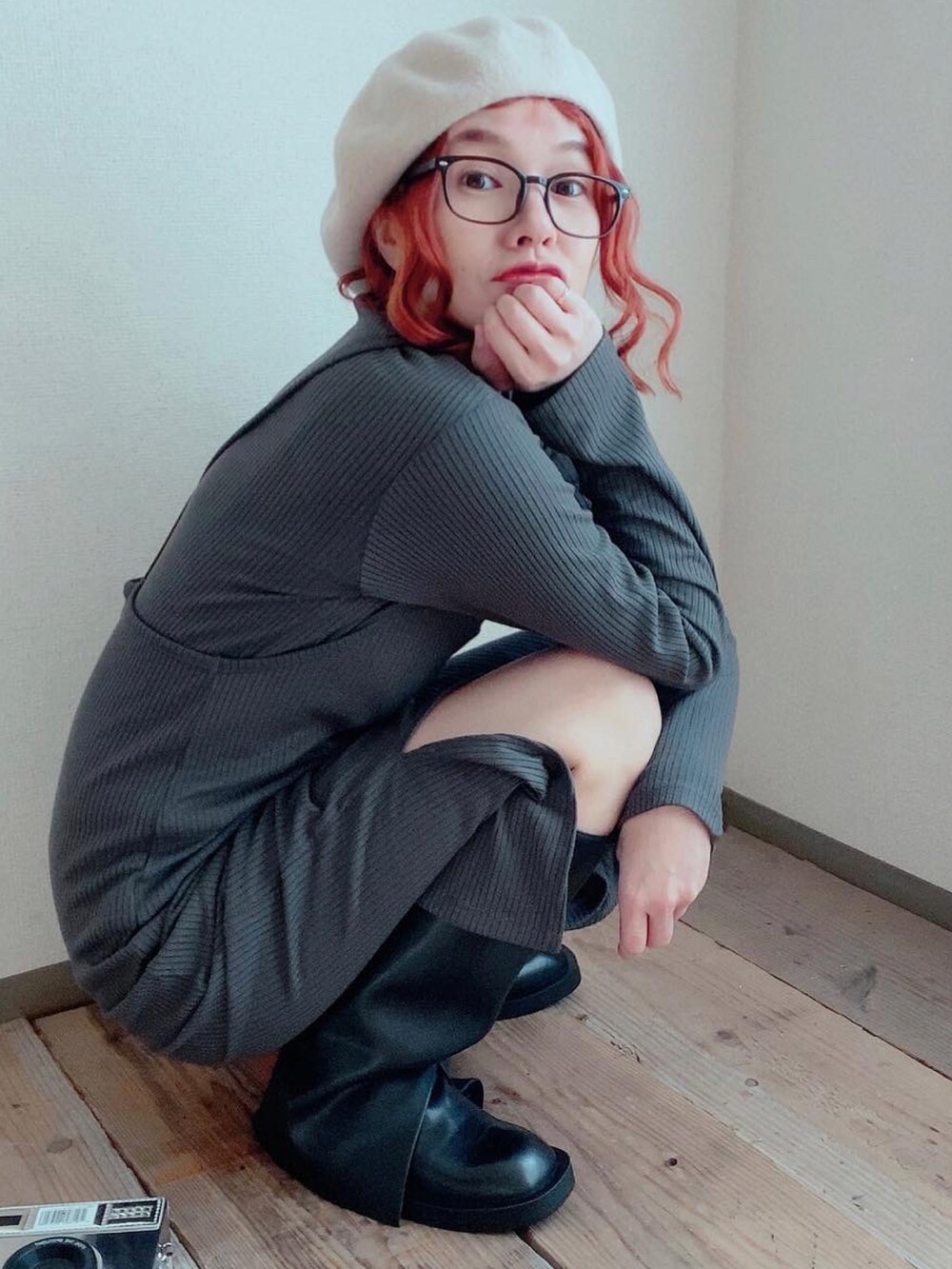 グレー系のワンピース、ブラック系のシューズ、ホワイト系のハンチング/ベレー帽を着用したレディースの冬コーディネートの2枚目の写真