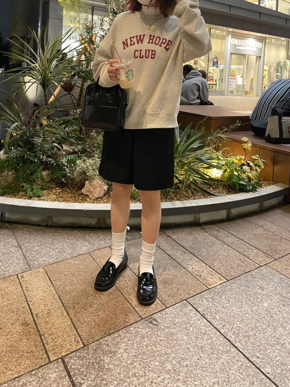 ホワイト系のニット/セーター、ブラック系のパンツ、ブラック系のローファーを着用したレディースの秋コーディネートの2枚目の写真