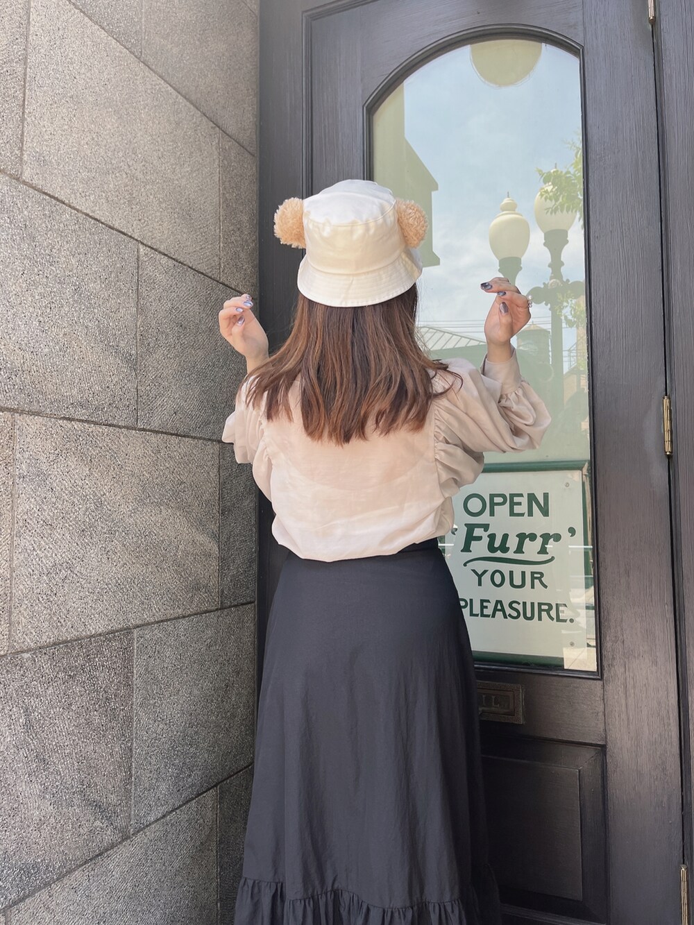 ベージュ系のシャツ/ブラウス、ブラック系のスカートを着用したレディースの夏コーディネートの2枚目の写真