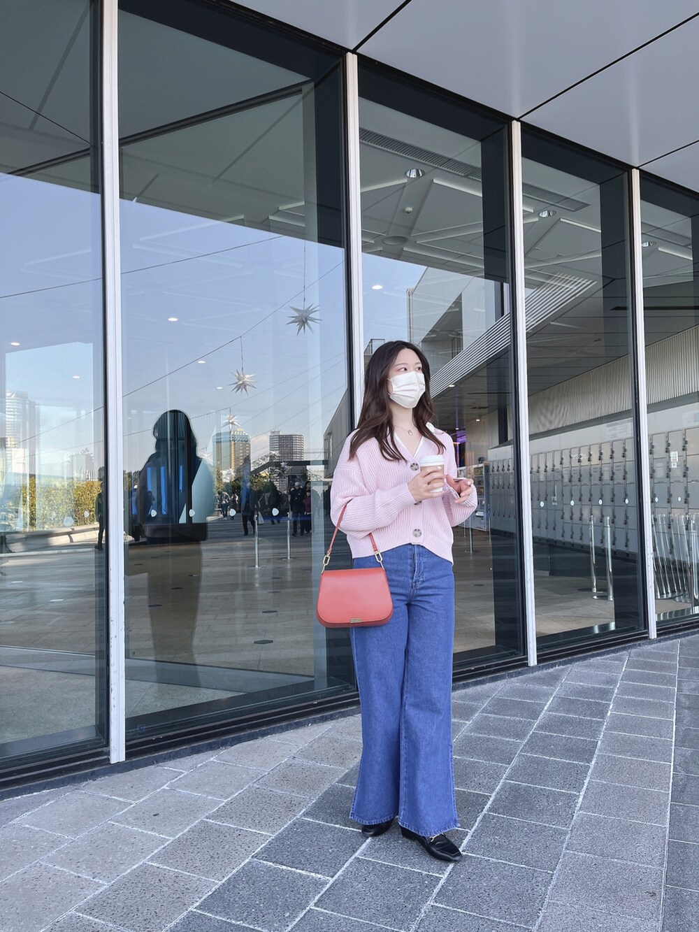 ピンク系のカーディガン/ボレロ、レッド系のショルダーバッグ、ゴールド系のネックレスを着用したレディースの春コーディネートの2枚目の写真