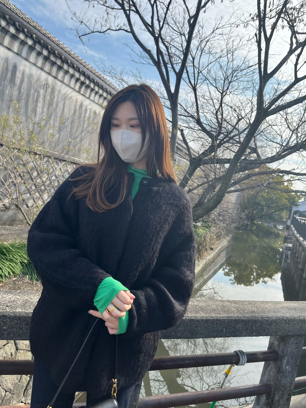 ブラック系のショルダーバッグ、ブラック系のその他アウター、ブルー系のデニムパンツを着用したレディースの春コーディネートの4枚目の写真