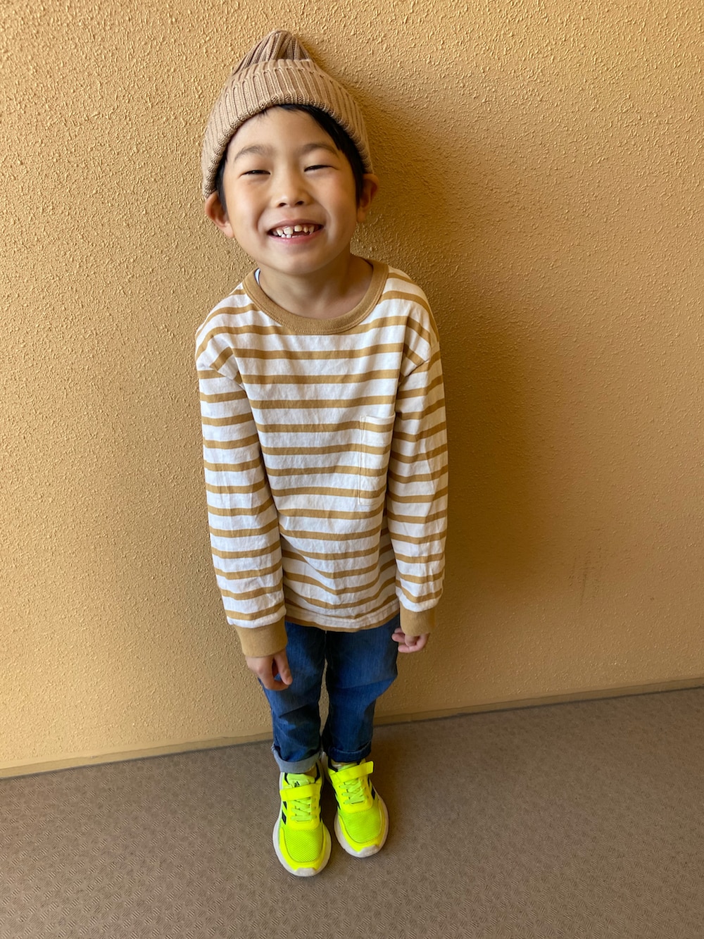 ホワイト系のトップス、ブルー系のパンツ、イエロー系のスニーカーを着用したキッズの秋コーディネートの2枚目の写真