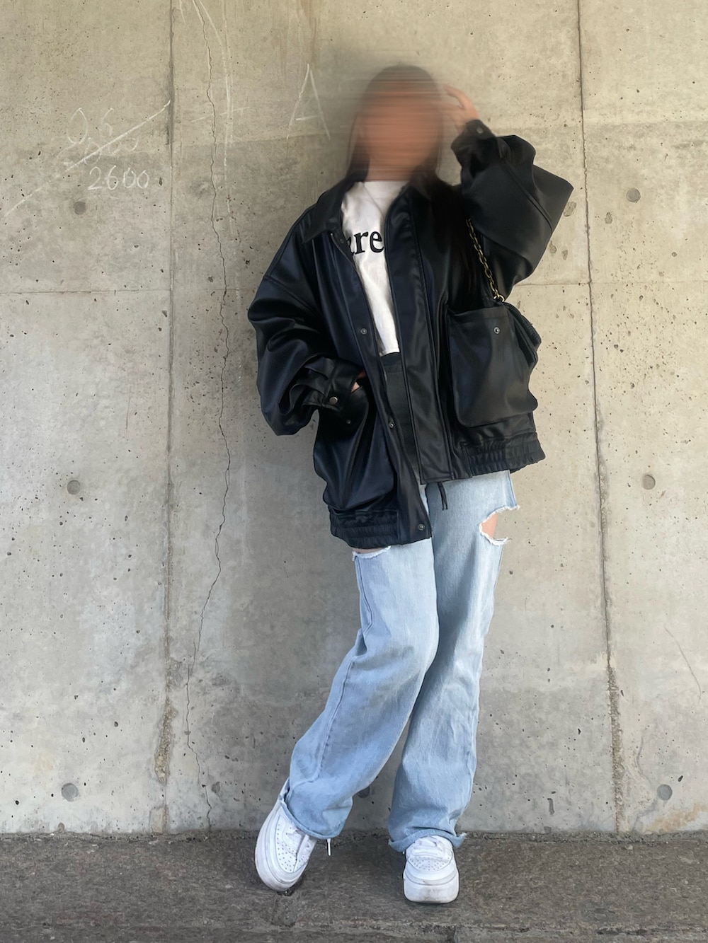 ホワイト系のTシャツ/カットソー、ブラック系のライダースジャケット、ブルー系のデニムパンツを着用したレディースの冬コーディネートの2枚目の写真