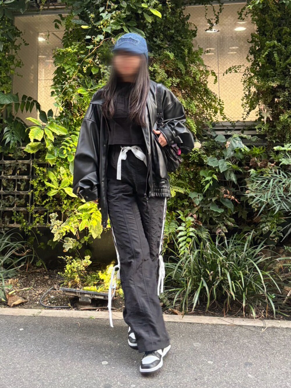 ブラック系のライダースジャケット、ブラック系のその他パンツ、ホワイト系のスニーカーを着用したレディースの春コーディネートの3枚目の写真