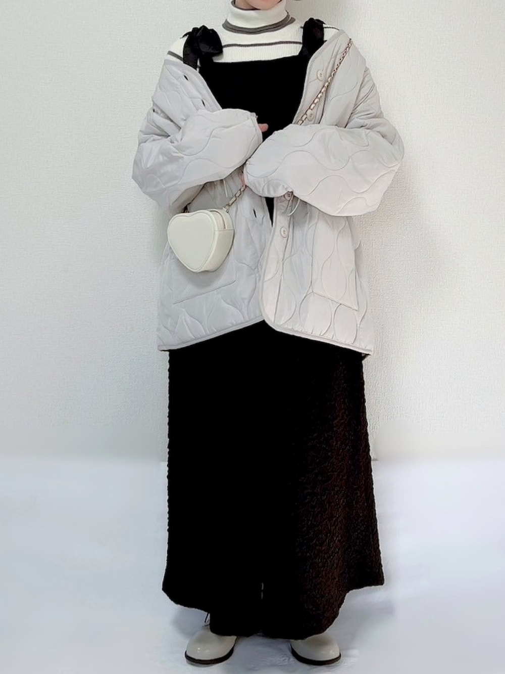 ホワイト系のノーカラージャケット、ブラウン系のニット/セーター、イエロー系のワンピース/ドレスを着用したレディースの秋コーディネートの2枚目の写真