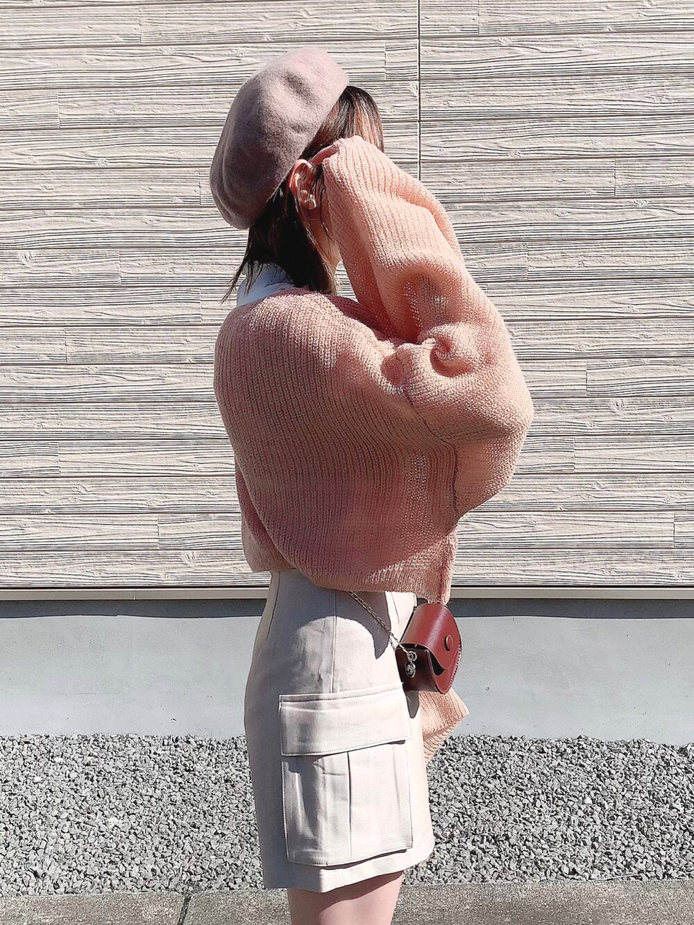 ピンク系のトップス、ベージュ系のパンツ、ブラウン系のショルダーバッグを着用したレディースの冬コーディネートの4枚目の写真