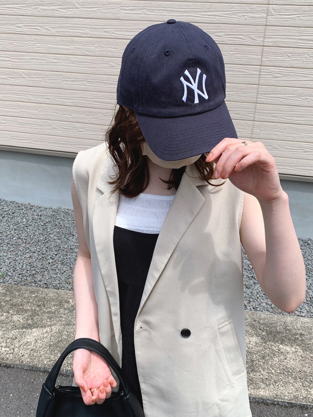 ホワイト系のベスト、ホワイト系のタンクトップ、ブラック系のサロペット/オーバーオールを着用したレディースの春コーディネートの2枚目の写真