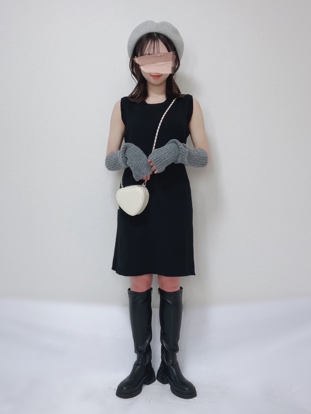 ブラック系のワンピース、ピンク系のバッグ、ブラック系のブーツを着用したレディースの冬コーディネートの2枚目の写真