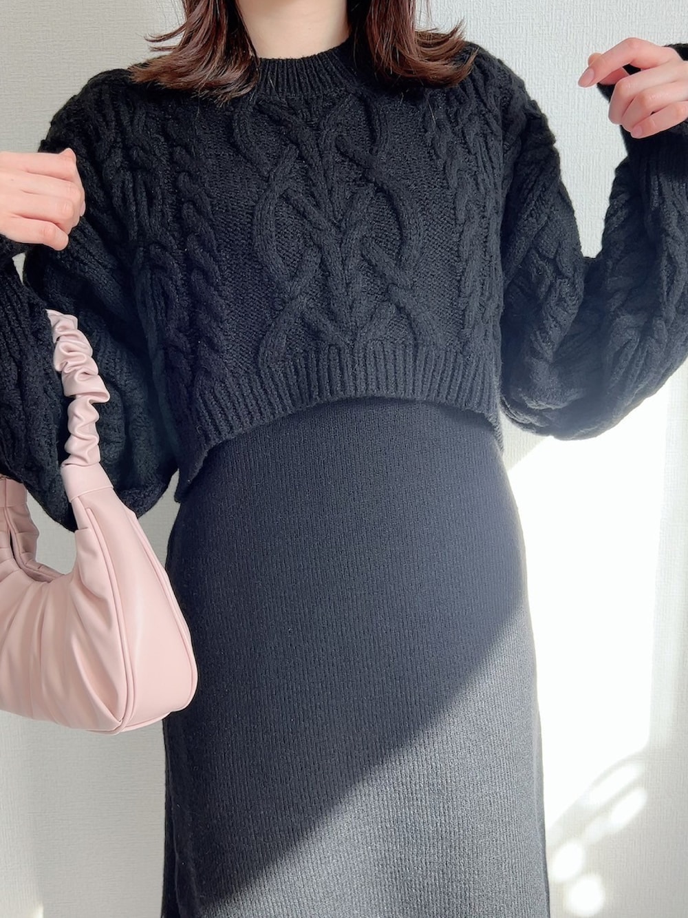 ブラック系のワンピース、ピンク系のバッグ、ブラック系のブーツを着用したレディースの冬コーディネートの4枚目の写真