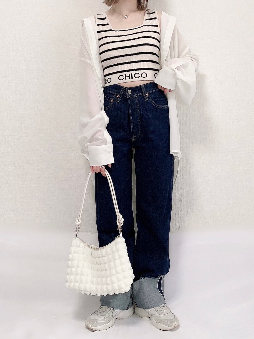 ホワイト系のシャツ/ブラウス、ホワイト系のタンクトップ、ブルー系のデニムパンツを着用したレディースの春コーディネートの3枚目の写真