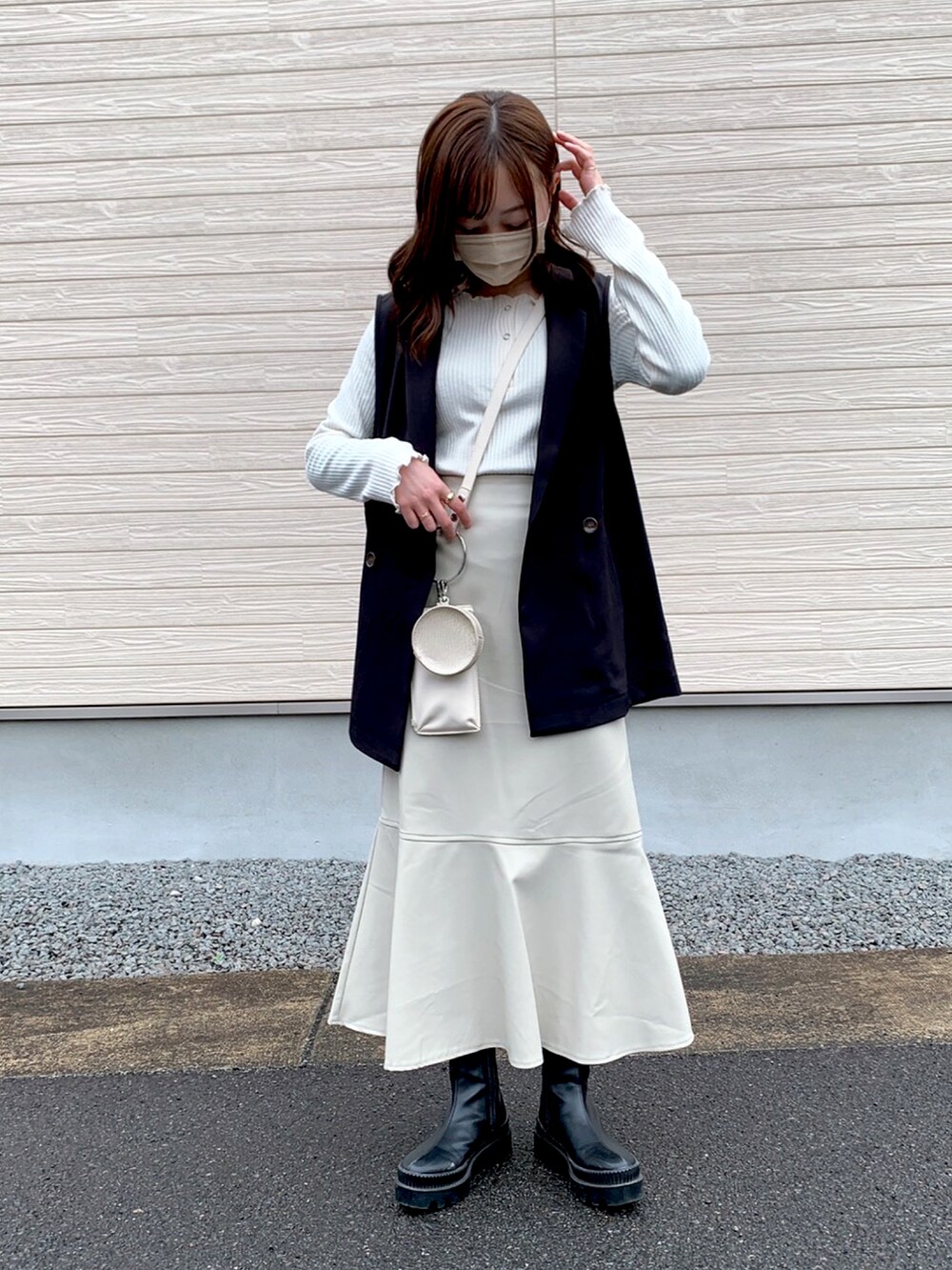 ブラック系のベスト、ホワイト系のTシャツ/カットソー、ホワイト系のショルダーバッグを着用したレディースの春コーディネートの2枚目の写真