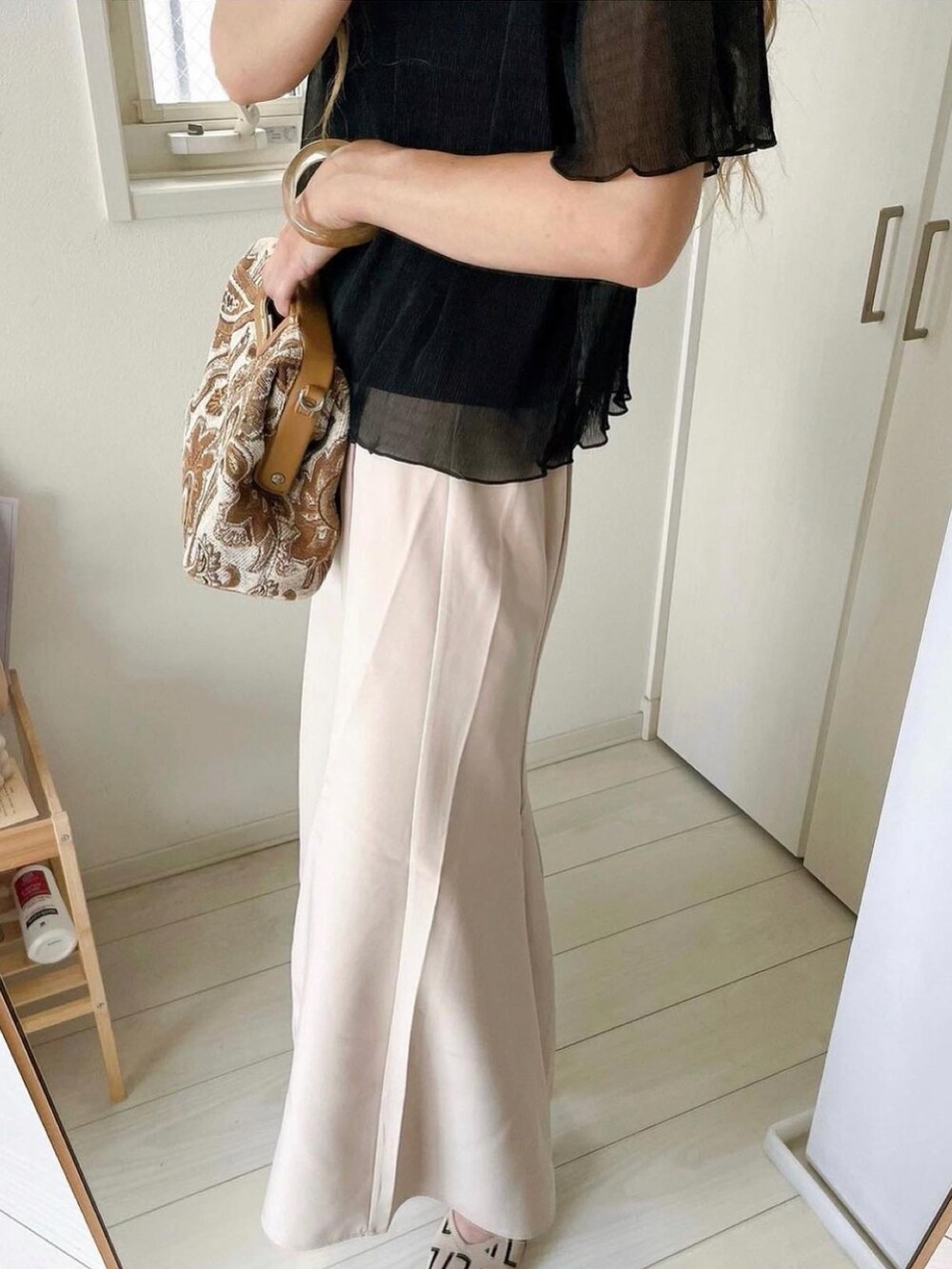 ブラック系のシャツ/ブラウス、ベージュ系のスカートを着用したレディースの夏コーディネートの3枚目の写真