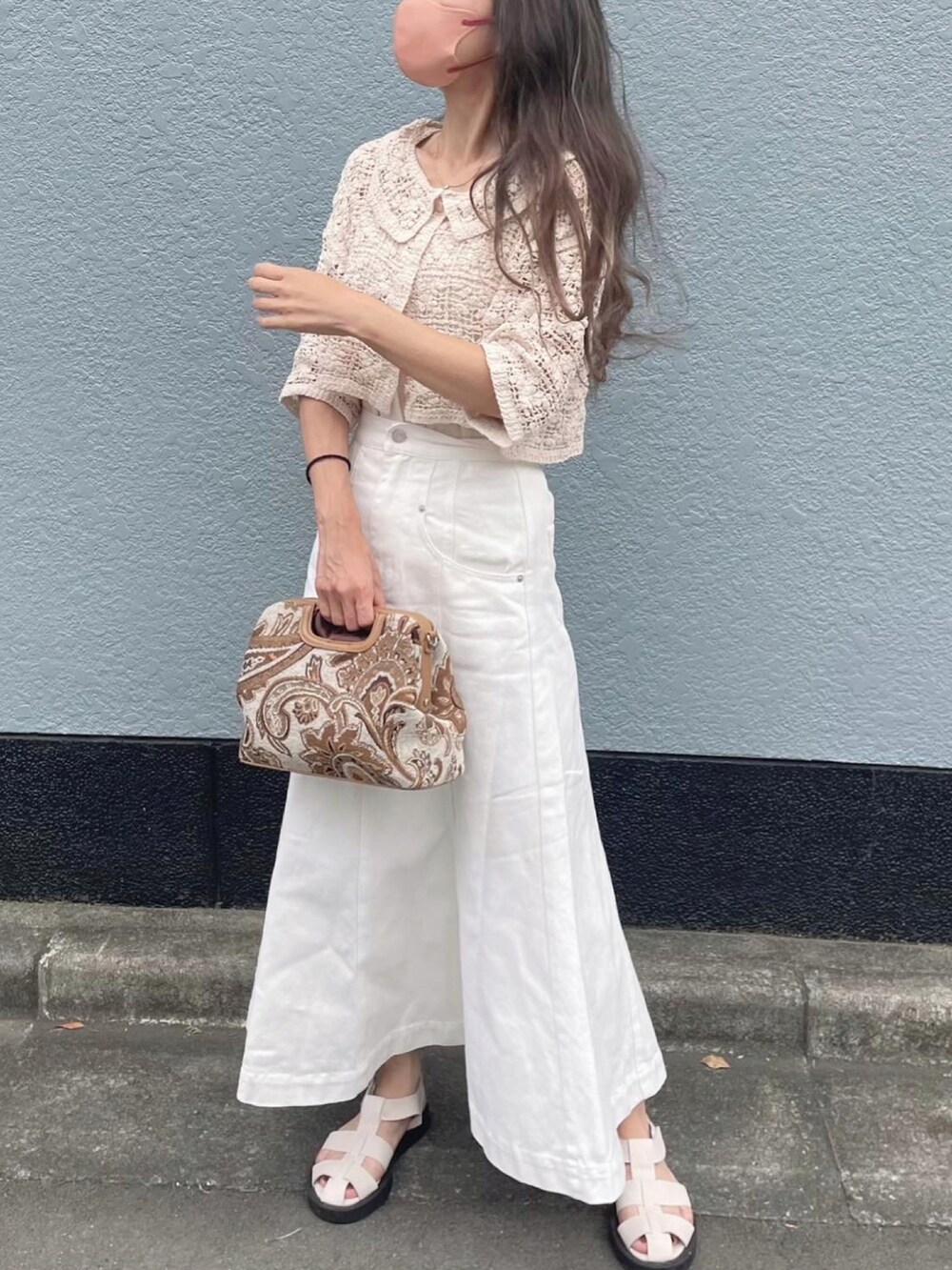 ベージュ系のカーディガン/ボレロ、ブラック系のスカート、ホワイト系のサンダルを着用したレディースの夏コーディネートの2枚目の写真