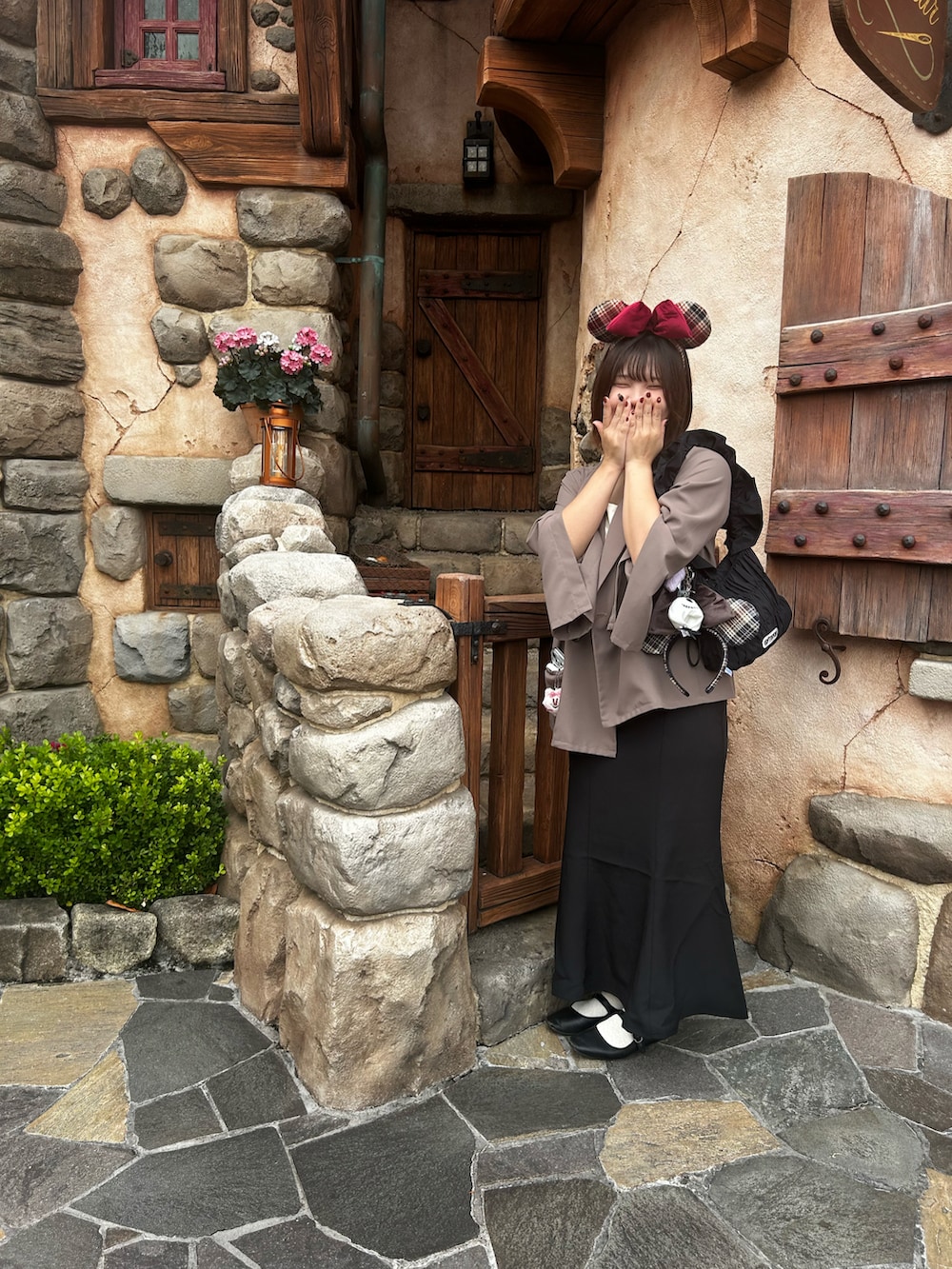 ブラック系のスカート、ブラウン系のテーラードジャケット、ブラック系のバッグを着用したレディースの秋コーディネートの2枚目の写真