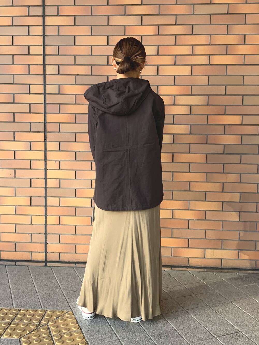 ベージュ系のワンピース、ホワイト系のバッグ、ブラウン系のジャケット/アウターを着用したレディースの冬コーディネートの2枚目の写真