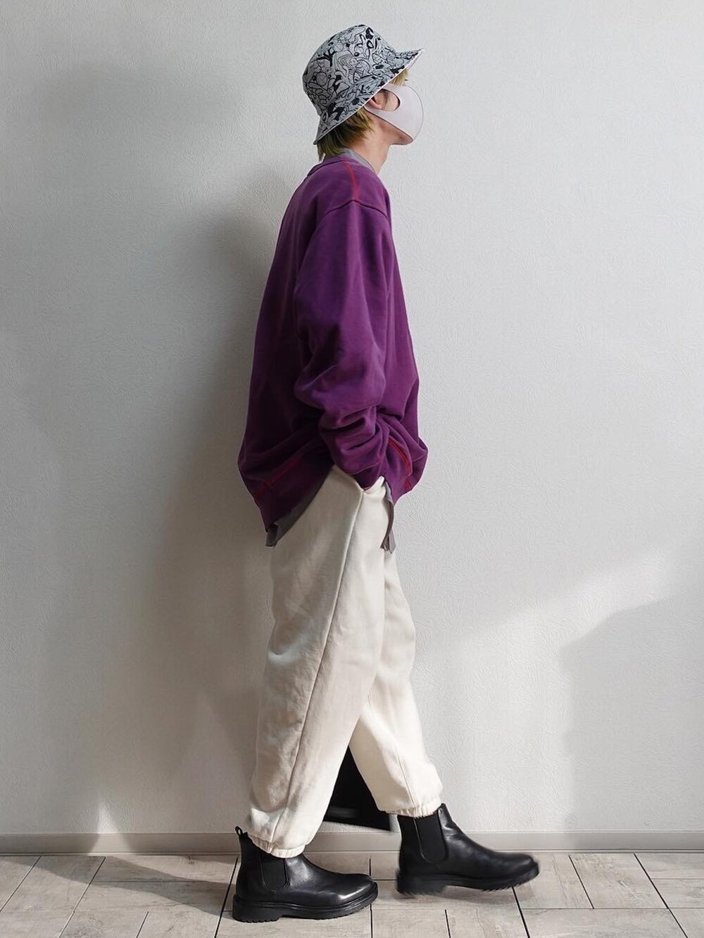 ホワイト系のスウェットパンツ、ブラック系のブーツ、ブラック系のトートバッグを着用したメンズの冬コーディネートの2枚目の写真